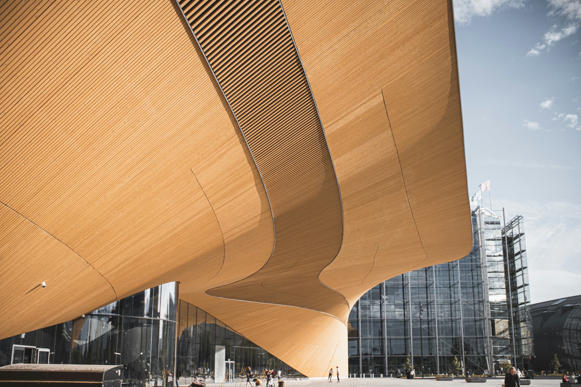 The curved timber underside of Oodi central library sweeping over the square below