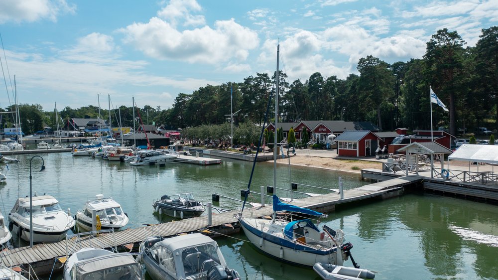 Sailing boats and red harbour buildings at Nauvo guest harbour in summer
