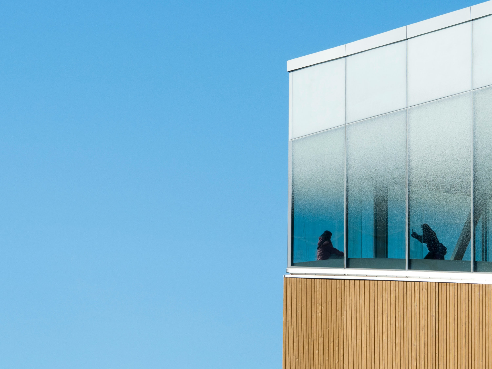 The glass corner of Oodi central library against a clear winter sky in Helsinki